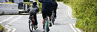 Family cycling along a country road in Wales, UK