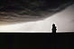 Silhouette of a man looking up at a darkening sky, Colorado, United States.