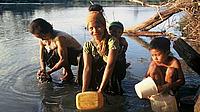 Tribal women collect water and wash children in the evening in a village which lacks access to sanitation, Vietnam