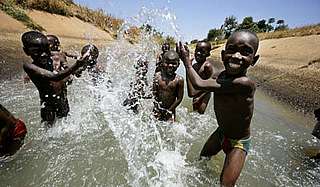 A group of boys play in the irrigation channel that runs through Rweja town, Tanzania. - © Brent Stirton / Getty Images / WWF-UK A group of boys play in the irrigation channel that runs through Rweja town, Tanzania.