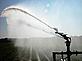 Irrigation equipment pumps water over a corn field.