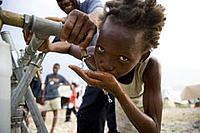 Drinking fresh water from a tank set up by the French Red Cross in Camp Dihaushtu, Port-au-Prince. - © Talia Frenkel/American Red Cross Drinking fresh water from a tank set up by the French Red Cross in Camp Dihaushtu, Port-au-Prince.