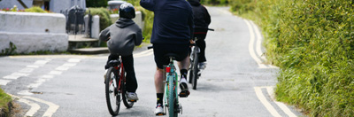 Family cycling along a country road in Wales, UK