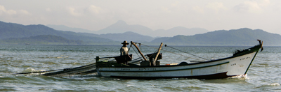 Man in fishing boat, Caneneia Estuary, Brazil