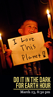Young boy holding a poster that says I love this Planet - for Earth Hour