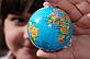 A girl holding an earth globe map of the world, showing Africa and South America.