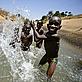 A group of boys play in the irrigation channel that runs through Rweja town, Tanzania. - © Brent Stirton / Getty Images / WWF-UK A group of boys play in the irrigation channel that runs through Rweja town, Tanzania.